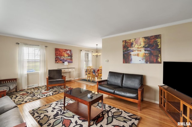living room with crown molding, light wood-style flooring, a chandelier, plenty of natural light, and baseboards