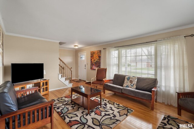 living area featuring stairs, crown molding, light wood-style floors, and baseboards