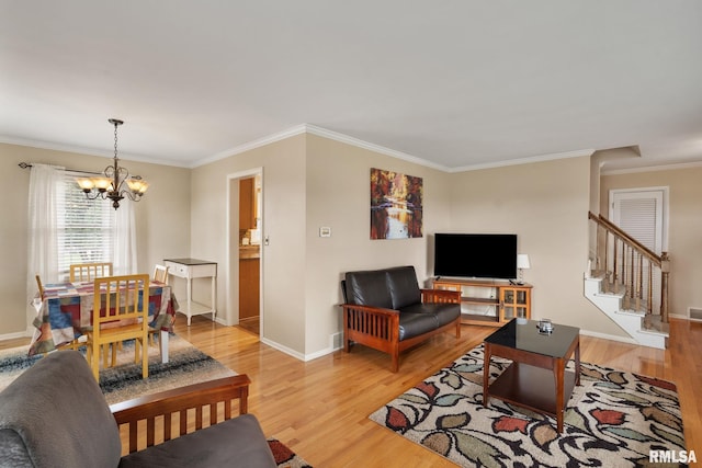 living room featuring light wood finished floors, a chandelier, ornamental molding, baseboards, and stairway