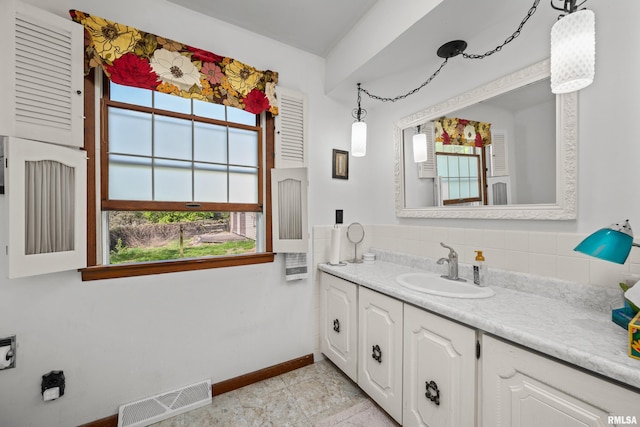 bathroom with plenty of natural light, vanity, and baseboards