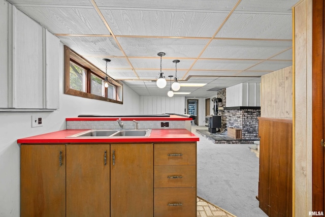 kitchen featuring a sink, a wood stove, and carpet floors