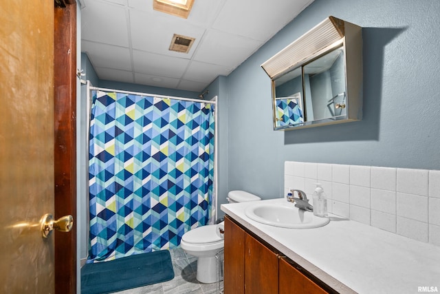 full bath featuring a paneled ceiling, toilet, tasteful backsplash, vanity, and a shower with shower curtain