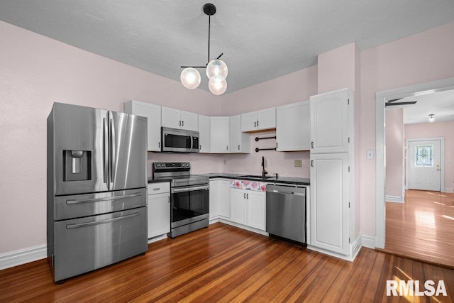 2350 Jefferson Ave, Davenport, IA 52803 - kitchen featuring appliances with stainless steel finishes, dark wood finished floors, baseboards, and dark countertops