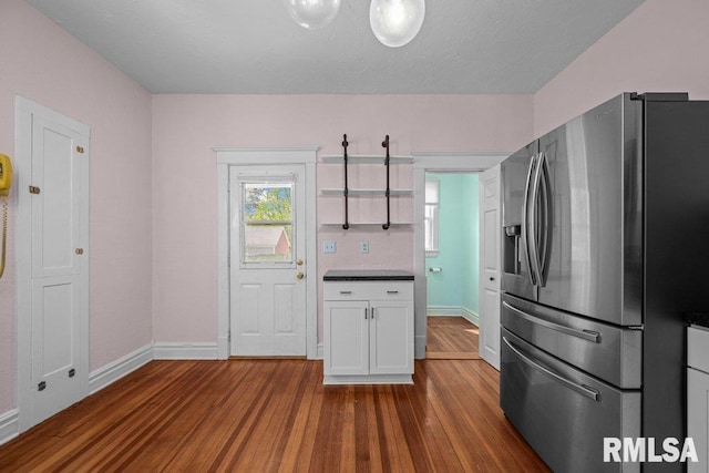 2350 Jefferson Ave, Davenport, IA 52803 - kitchen with stainless steel fridge with ice dispenser, dark wood-style floors, baseboards, and white cabinets