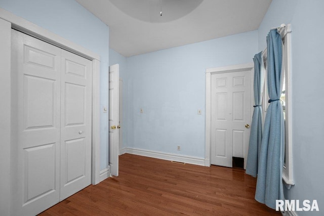 2350 Jefferson Ave, Davenport, IA 52803 - unfurnished bedroom with wood finished floors, baseboards, and ceiling fan