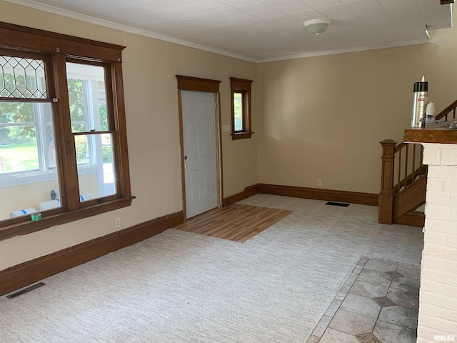 carpeted entryway with ornamental molding, stairs, and baseboards