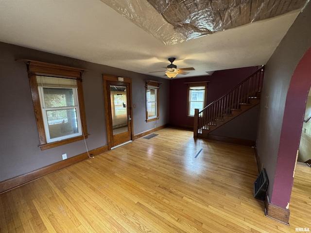 foyer entrance with ceiling fan, baseboards, light wood-style floors, and stairway
