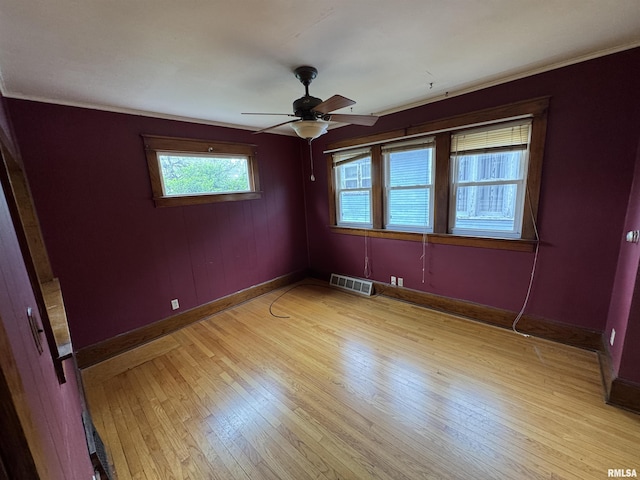unfurnished room with light wood-type flooring, baseboards, a ceiling fan, and ornamental molding