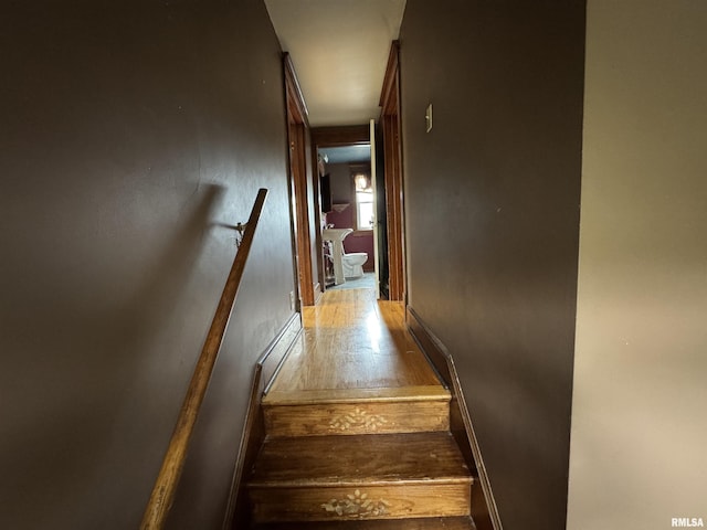 stairway with hardwood / wood-style floors and baseboard heating