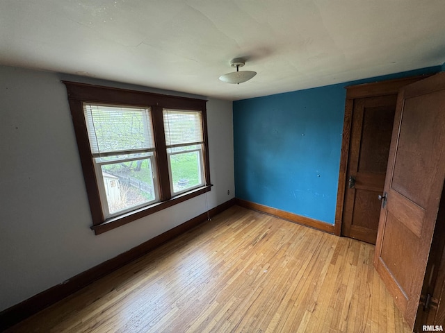 spare room with light wood-style floors and baseboards