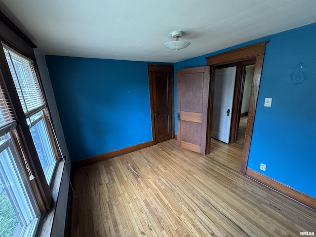spare room featuring baseboards and light wood-style floors