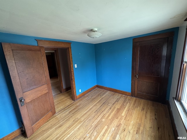 unfurnished bedroom with light wood finished floors and baseboards