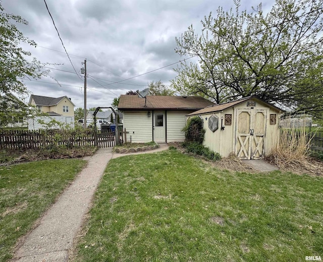 rear view of house featuring an outdoor structure and a storage unit