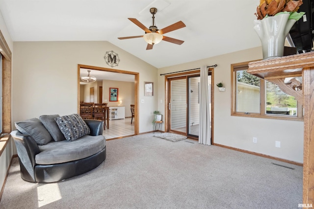 living room featuring ceiling fan, vaulted ceiling, carpet floors, baseboards, and a chandelier