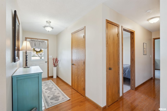 hallway with light wood finished floors and baseboards