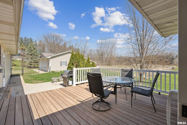 wooden deck with outdoor dining space and area for grilling