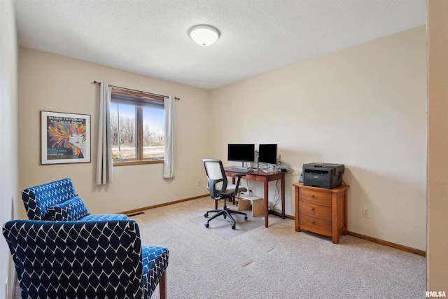 carpeted office with baseboards and a textured ceiling