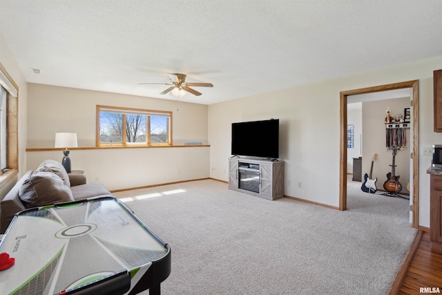 carpeted living room featuring ceiling fan and baseboards