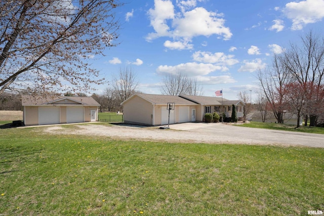 view of front of home with a front yard, driveway, a chimney, and a detached garage