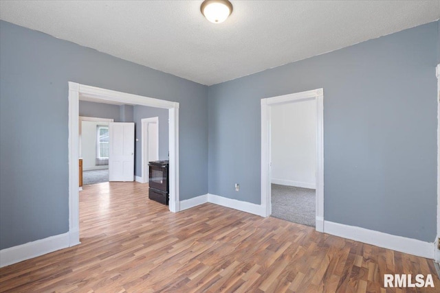 720 Wilkes Ave, Davenport, IA 52802 - empty room with wood finished floors, baseboards, and a textured ceiling