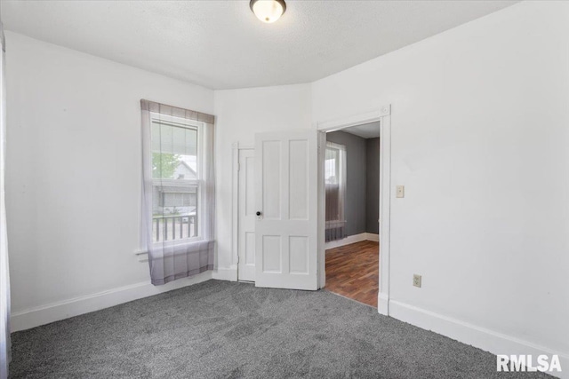 720 Wilkes Ave, Davenport, IA 52802 - unfurnished bedroom featuring multiple windows, carpet flooring, and baseboards