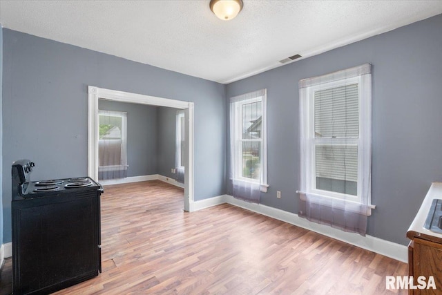 720 Wilkes Ave, Davenport, IA 52802 - empty room with light wood finished floors, healthy amount of natural light, a textured ceiling, and baseboards