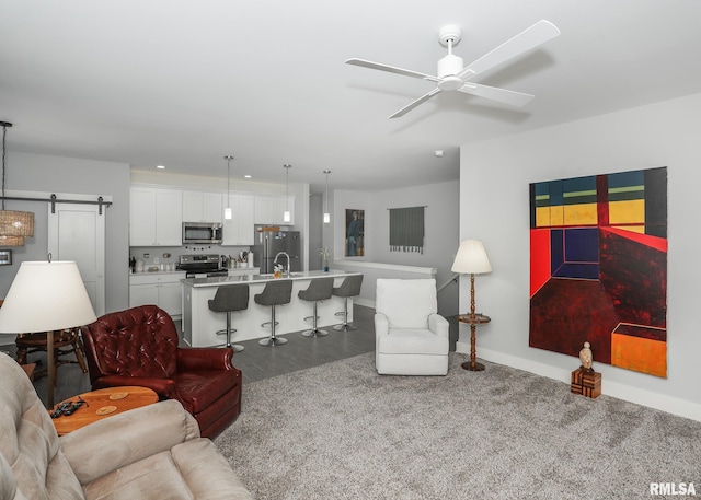 6811 Genesis Way, Bettendorf, IA 52722 - living area featuring a ceiling fan, baseboards, carpet floors, a barn door, and recessed lighting