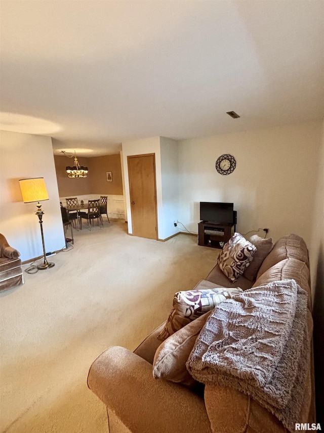 carpeted living area featuring a chandelier