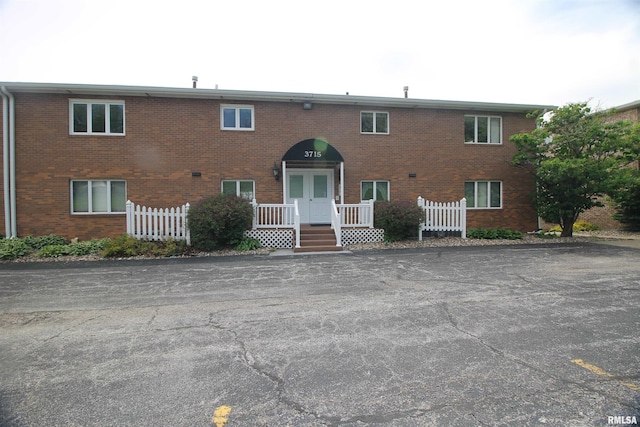 view of property featuring fence and brick siding