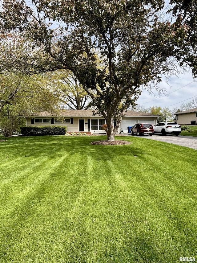 view of front of home with asphalt driveway, a garage, and a front yard