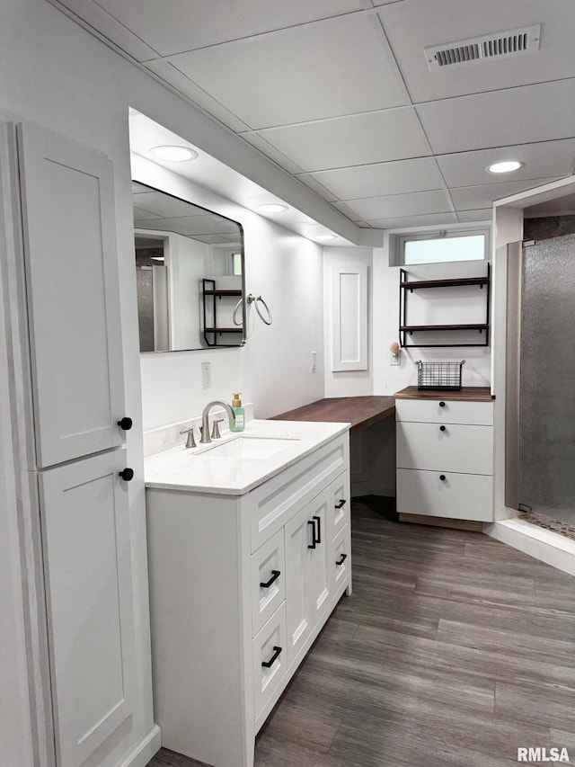 full bathroom with wood finished floors, a shower stall, vanity, and recessed lighting