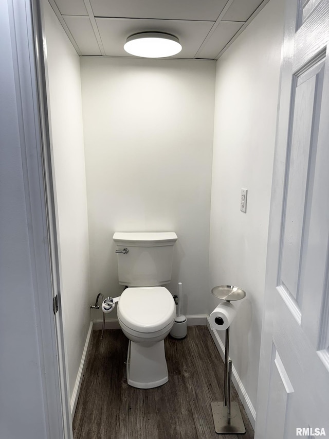 bathroom with wood finished floors, baseboards, and toilet