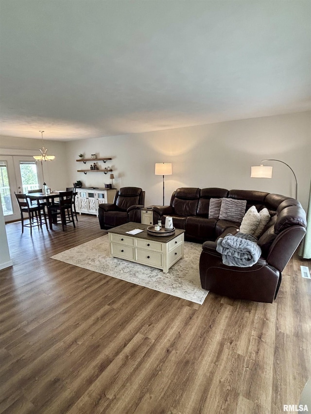 living area featuring dark wood finished floors and a chandelier