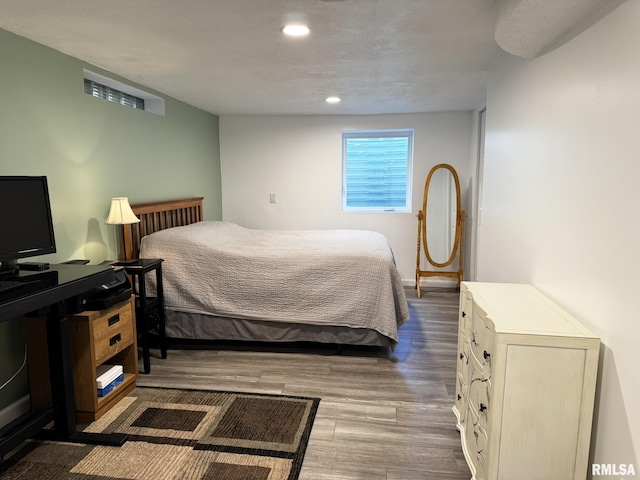 bedroom with wood finished floors and recessed lighting