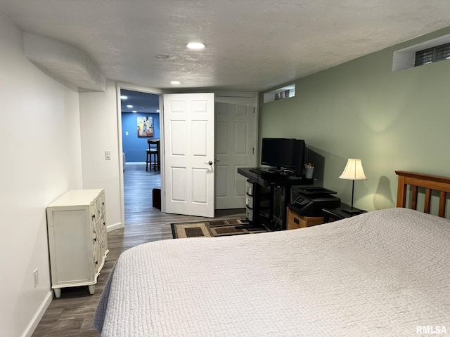 bedroom with baseboards, dark wood-style floors, recessed lighting, and a textured ceiling