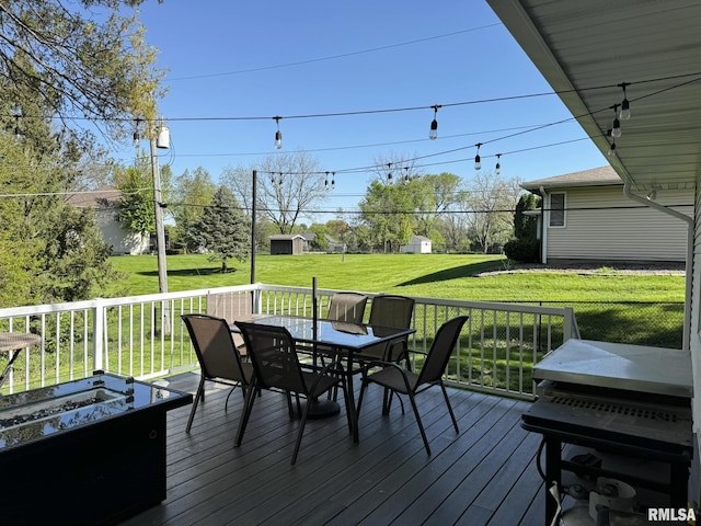 wooden deck featuring outdoor dining area and a yard