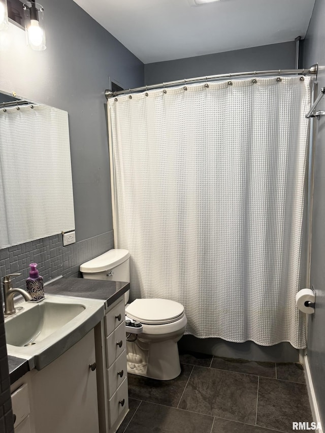 bathroom featuring vanity, toilet, tile patterned floors, and tasteful backsplash