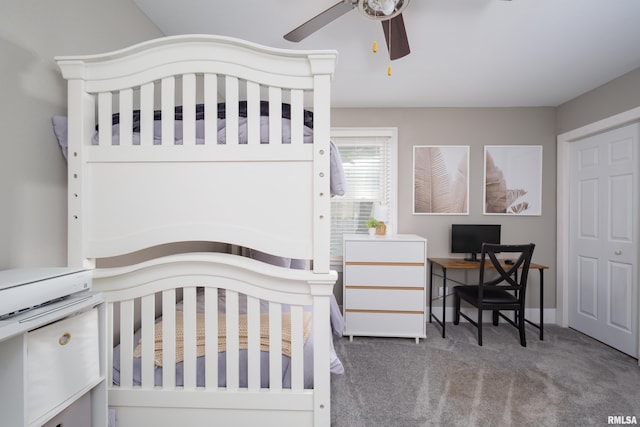 carpeted bedroom featuring an office area and a ceiling fan