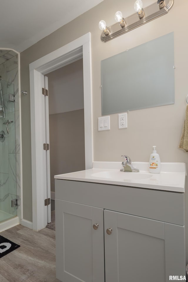 bathroom featuring a stall shower, wood finished floors, and vanity