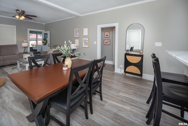 dining area with a ceiling fan, ornamental molding, light wood-type flooring, and baseboards