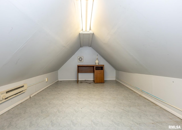 additional living space featuring vaulted ceiling, tile patterned floors, and a baseboard heating unit