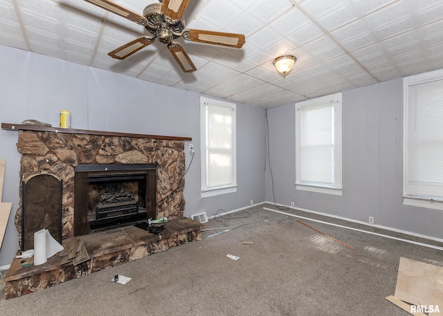 unfurnished living room featuring a fireplace, carpet, and a ceiling fan