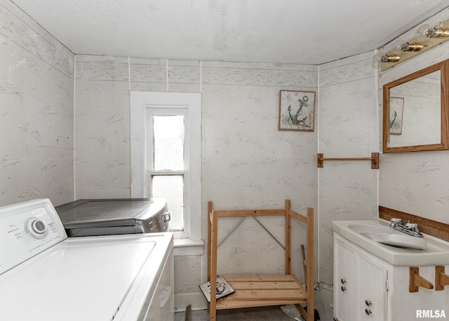 clothes washing area with washer and dryer and wallpapered walls