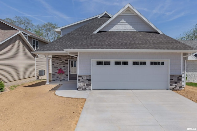 7 Welcome Center Ct, Le Claire, IA 52753 - craftsman-style home featuring stone siding, a shingled roof, a garage, and driveway