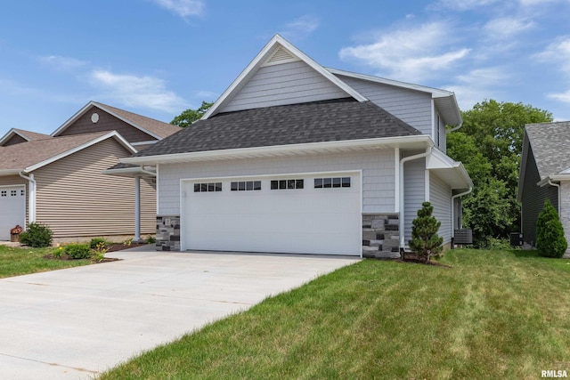 7 Welcome Center Ct, Le Claire, IA 52753 - view of front of property featuring a shingled roof, stone siding, a front lawn, and driveway