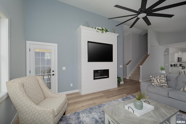 7 Welcome Center Ct, Le Claire, IA 52753 - living room with a ceiling fan, light wood finished floors, a large fireplace, and stairway