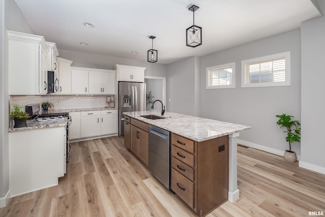 7 Welcome Center Ct, Le Claire, IA 52753 - kitchen featuring stainless steel appliances, a kitchen island with sink, light wood-style flooring, tasteful backsplash, and recessed lighting