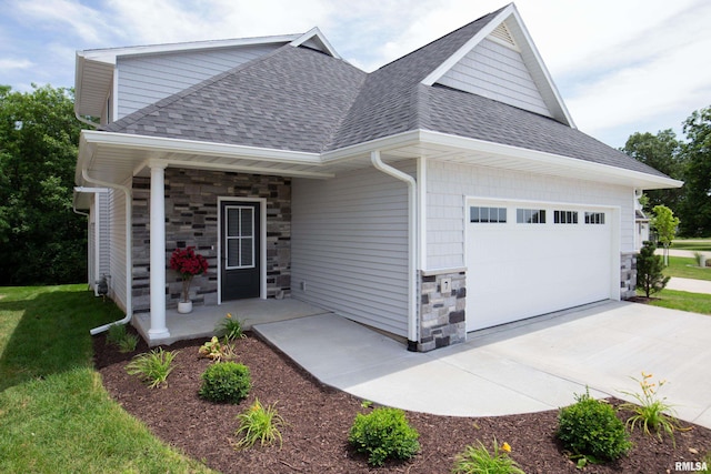 7 Welcome Center Ct, Le Claire, IA 52753 - view of front of house featuring stone siding, a shingled roof, covered porch, an attached garage, and a front yard