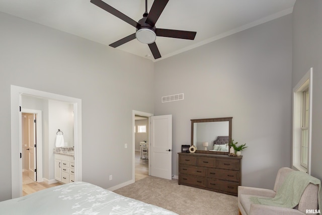 7 Welcome Center Ct, Le Claire, IA 52753 - bedroom featuring a towering ceiling, ornamental molding, light colored carpet, connected bathroom, and a ceiling fan