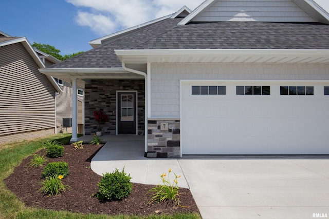 7 Welcome Center Ct, Le Claire, IA 52753 - view of front of house featuring a shingled roof, a garage, driveway, and stone siding